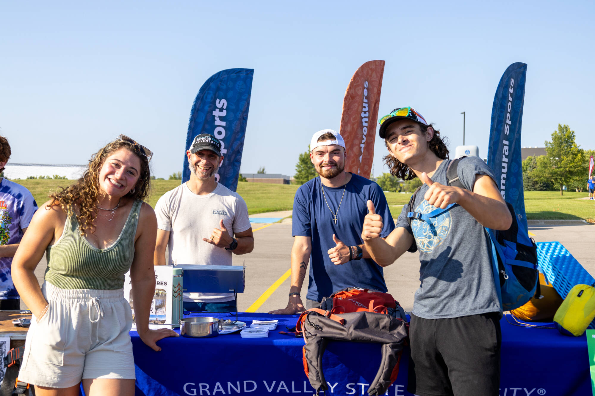 Group of 4 students posing thumbs up for a photo